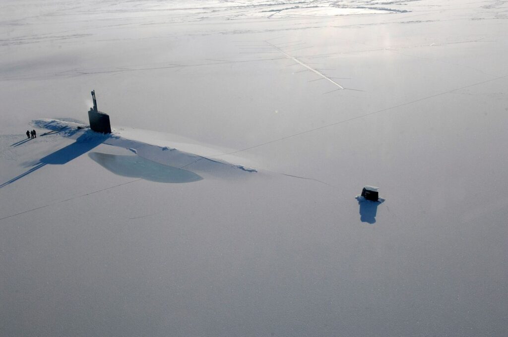 broken arctic sea ice floating on dark ocean water